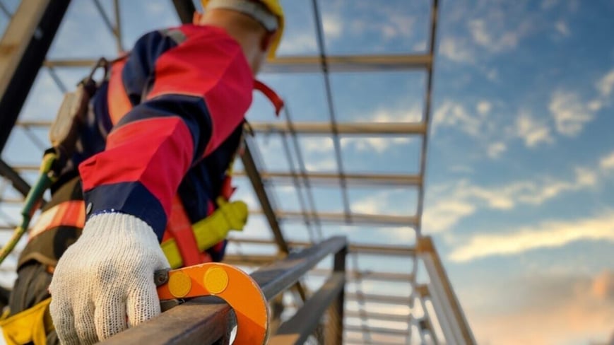 Small business owner following OSHA regulations to scale a ladder. 